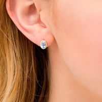 Oval Swiss Blue Topaz and 0.088 CT. T.W. Diamond Frame Stud Earrings in 10K Gold|Peoples Jewellers