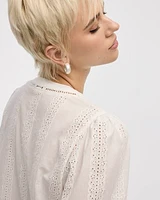 Blouse à col fendu et manches bouffantes avec garnitures oeillets