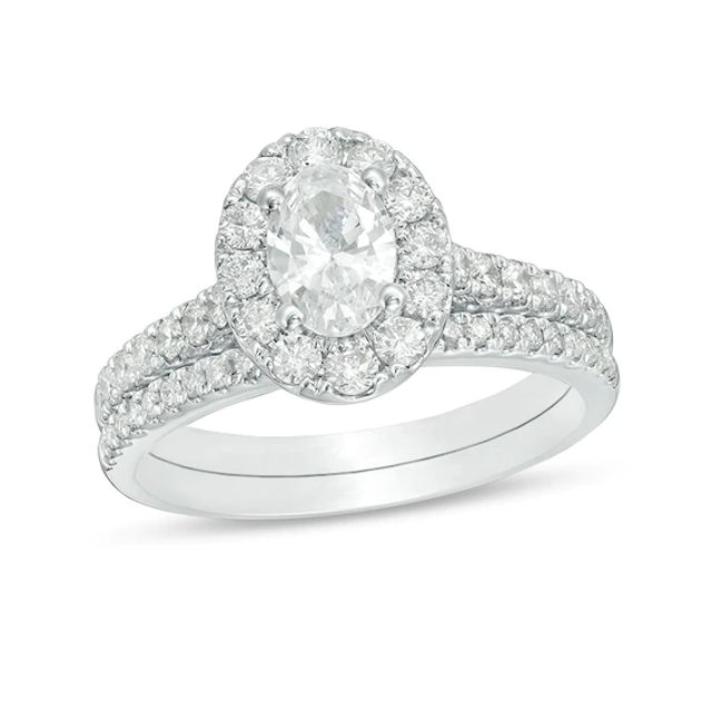 Previously Owned - Celebration Ideal 1-1/2 CT. T.w. Oval Diamond Frame Bridal Set in 14K White Gold (I/I1)