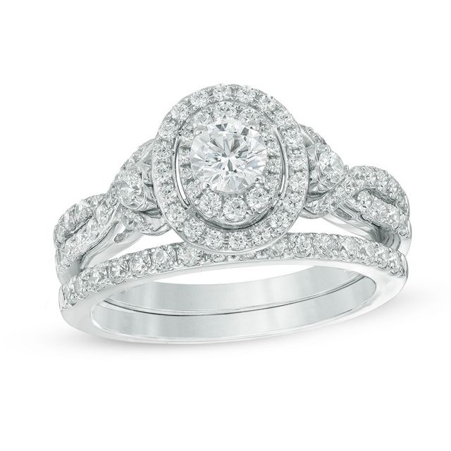 Previously Owned - Celebration Ideal 1-1/5 CT. T.w. Diamond Layered Oval Frame Crossover Bridal Set in 14K White Gold